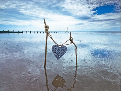 Picture of HEART TIED UP ON WOODEN STICKS AT THE BEACH