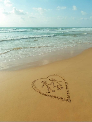 Picture of COUPLE IN HEART DRAWN ON SAND AT THE BEACH