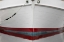 Picture of ALASKA, HOONAH BOW OF A BOAT REFLECTS IN WATER