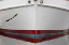 Picture of ALASKA, HOONAH BOW OF A BOAT REFLECTS IN WATER