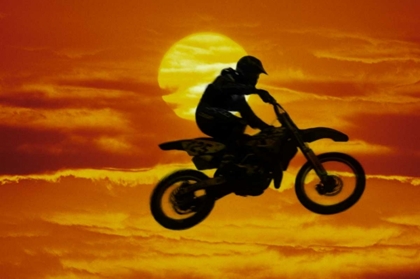Picture of MOTOCROSS RACER DOING JUMP IN FRONT OF BIG SUN