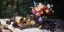 Picture of VASE OF FLOWERS AND FRUIT ON A DRAPED TABLE
