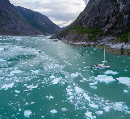 Picture of ALASKA-AERIAL VIEW S/V ABUELOS MOTORING AMONG ICEBERGS FLOATING NEAR CALVING FACE OF LECONTE GLACIER