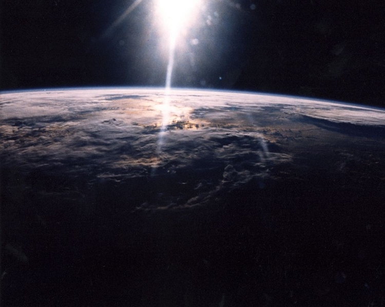 Picture of SUNLIGHT OVER EARTH AS SEEN BY DISCOVERY CREW
