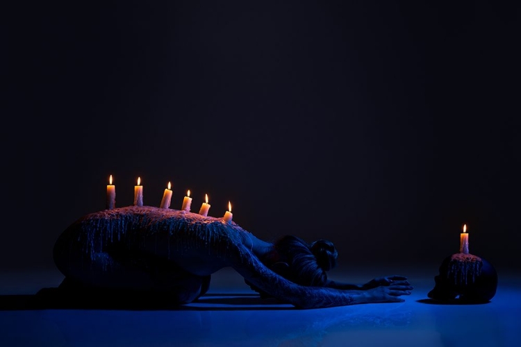 Picture of BURNING CANDLES ON BACK OF LADY BOWING DOWN IN DARKNESS