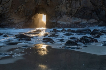 Picture of SUN SHINES THROUGH A TUNNEL IN A SEA CLIFF IN THE BIG SUR AREA.