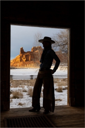 Picture of USA- SHELL- WYOMING. HIDEOUT RANCH WITH COWGIRL SILHOUETTED IN DOORWAY OF LOG CABIN. 