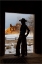Picture of USA- SHELL- WYOMING. HIDEOUT RANCH WITH COWGIRL SILHOUETTED IN DOORWAY OF LOG CABIN. 