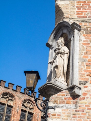 Picture of BELGIUM-BRUGGE. A STONE STATUE ON THE CORNERSTONE OF A BUILDING.
