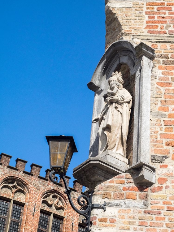 Picture of BELGIUM-BRUGGE. A STONE STATUE ON THE CORNERSTONE OF A BUILDING.
