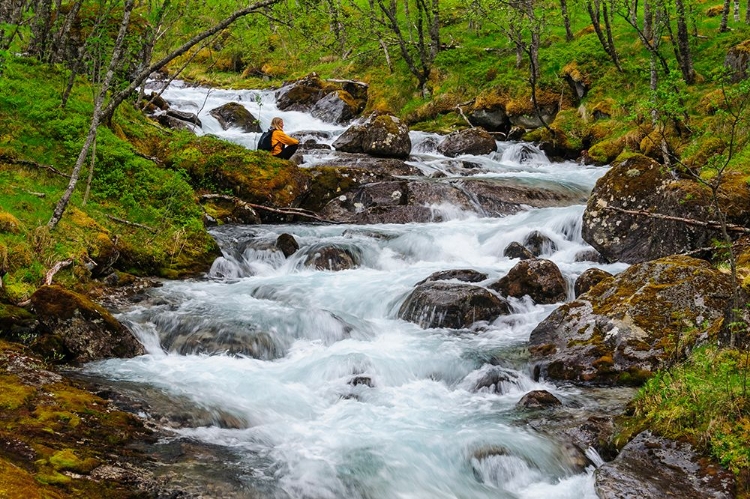 Picture of NORWAY-NORDLAND-TYSFJORD. WOMAN SITTING ALONG STORELVA-RIVER THAT FLOWS FROM STETIND MOUNTAIN