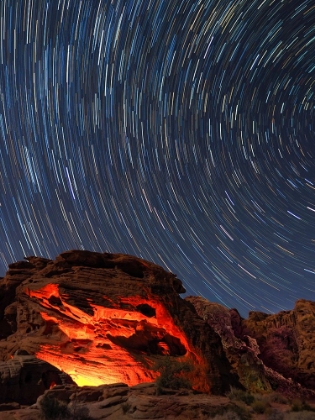 Picture of USA-NEVADA. VALLEY OF FIRE STATE PARK-STAR TRAILS AND CAMPFIRE GLOWING IN SANDSTONE ROCKS